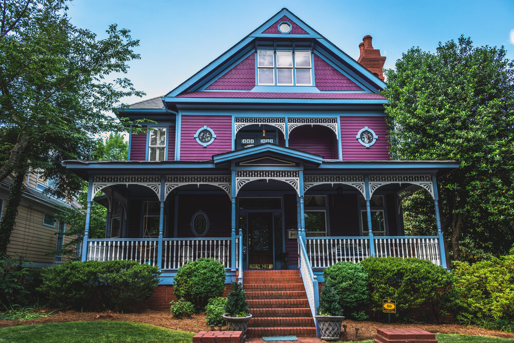 Traditional Southern house with horizontal siding and porch, in purple and blue colors.