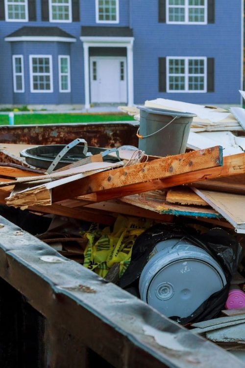 A dumpster piled high with junk wood and other house hold junk